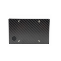 Black carbon fiber plate with circular cutouts on a white background